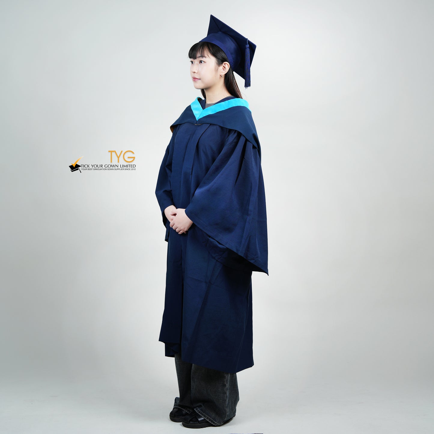 A profile view of a person wearing a blue graduation gown and cap on a white background