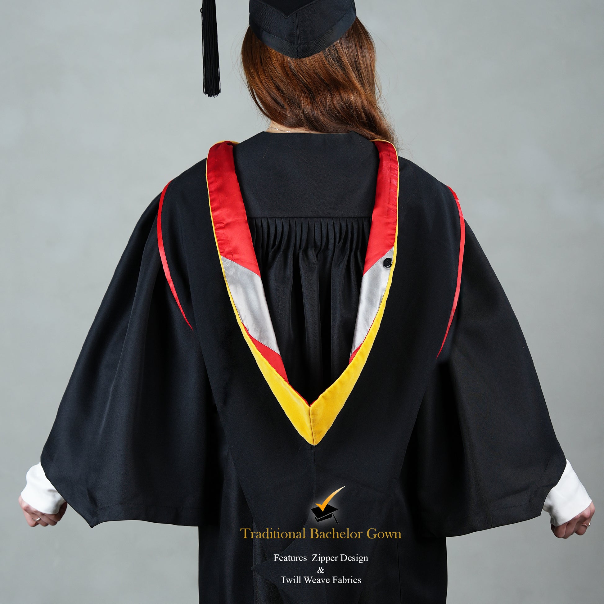 Back view of a person wearing a black bachelor graduation gown with a red, white, and gold satin hood and a mortarboard cap.