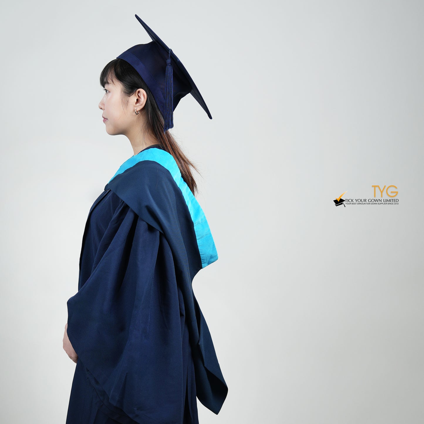A side view of a person wearing a blue graduation gown and cap on a white background