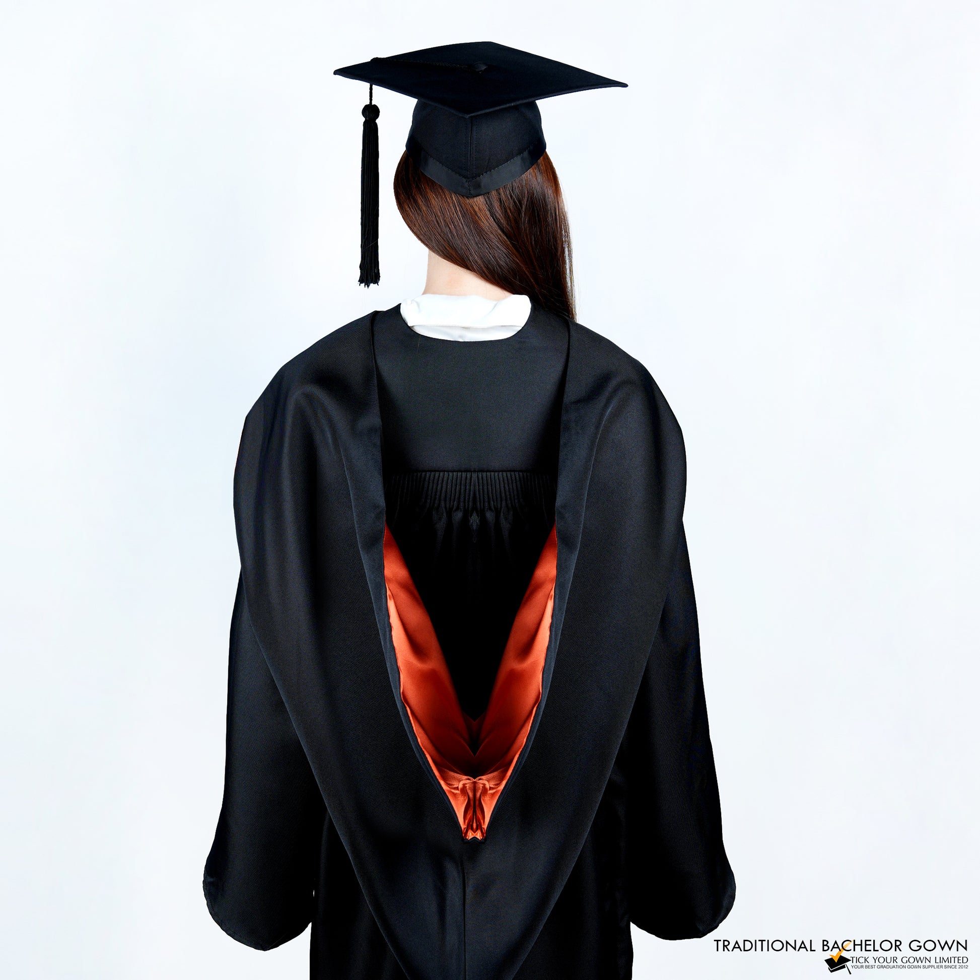 A person wearing a black bachelor graduation gown from the back with a colored inner satin hood, and a mortarboard