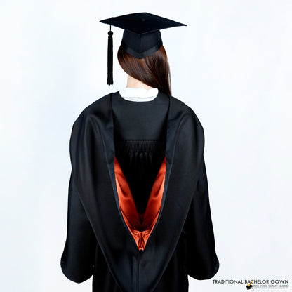 A person wearing a black bachelor graduation gown from the back with a colored inner satin hood, and a mortarboard