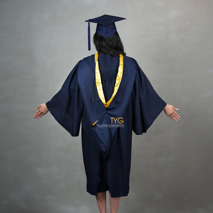 A full back view of a graduate in a navy cap and gown with a yellow hood against a gray background