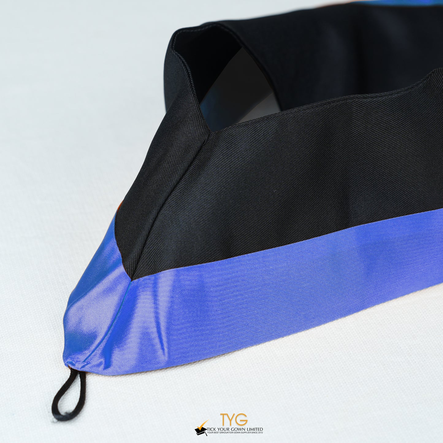 Detailed view of a bachelor’s graduation hood in black with navy satin lining.