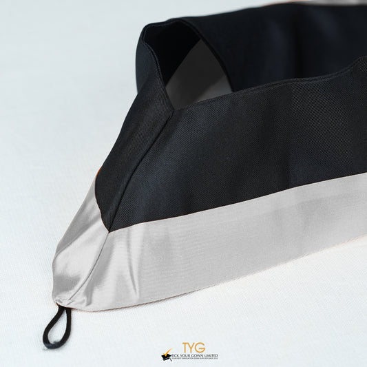 Detailed view of a bachelor’s graduation hood in black with silver satin lining.
