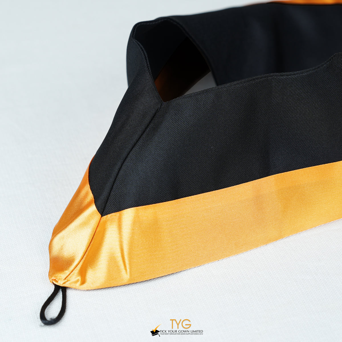Detailed view of a bachelor’s hood in black with gold satin lining.
