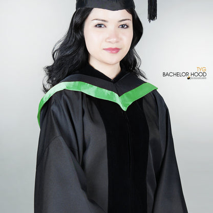 Graduate in black graduation gown with a green bachelor hood against a plain background