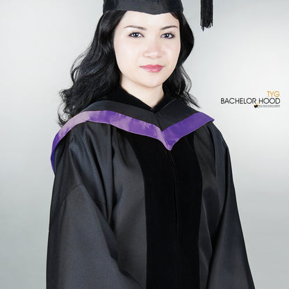 Graduate in black graduation gown with a light purple bachelor hood against a plain background