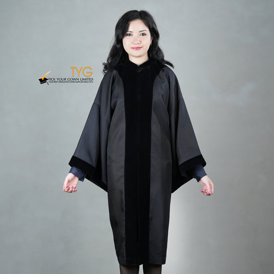 A person wearing a classic black velvet traditional graduation gown