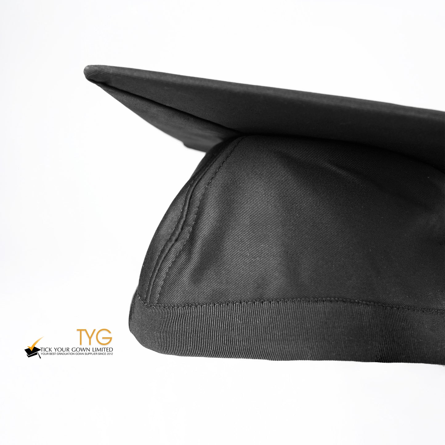 A detailed view of a black graduation cap with a black tassel on a white background.