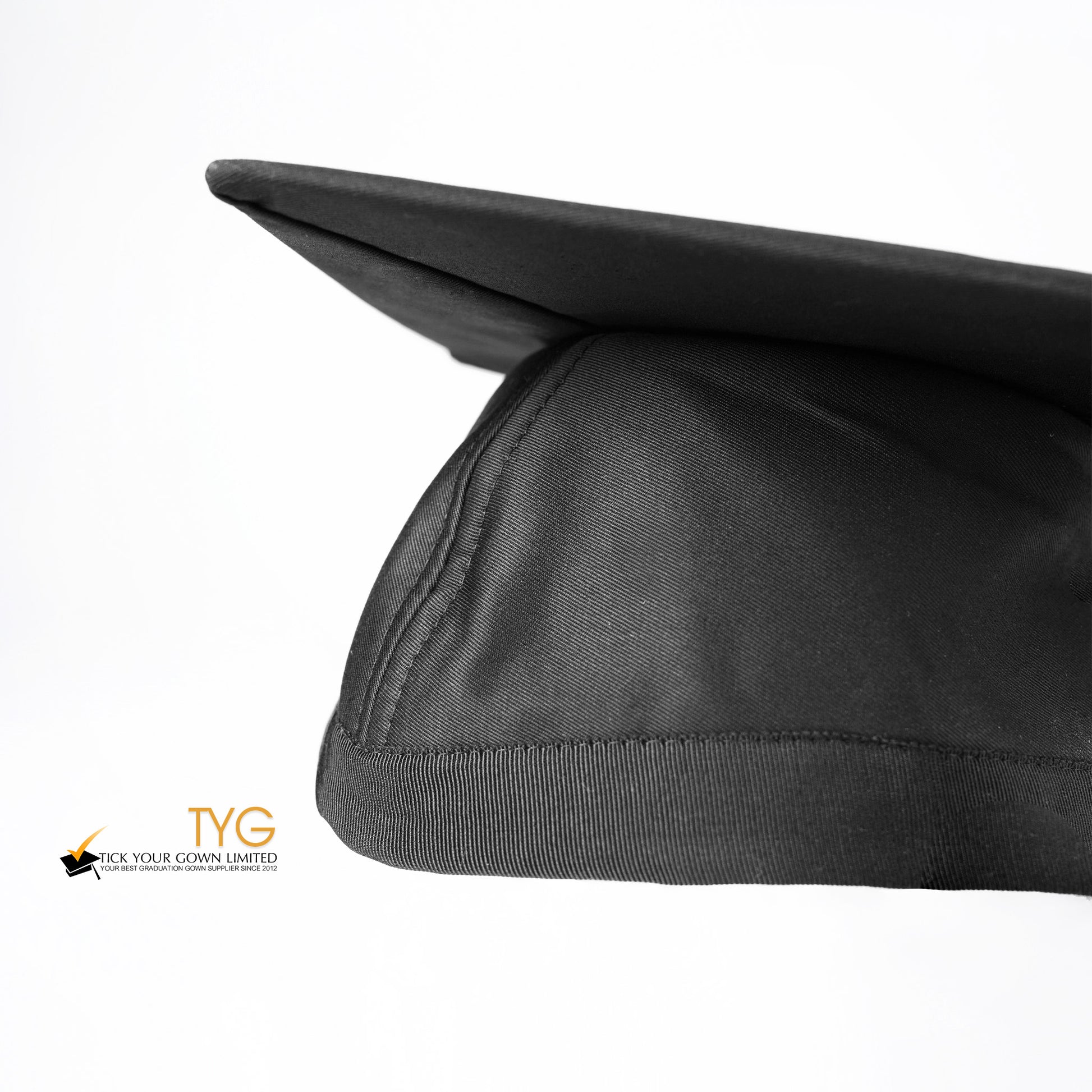 A detailed view of a black graduation cap with a black tassel on a white background.