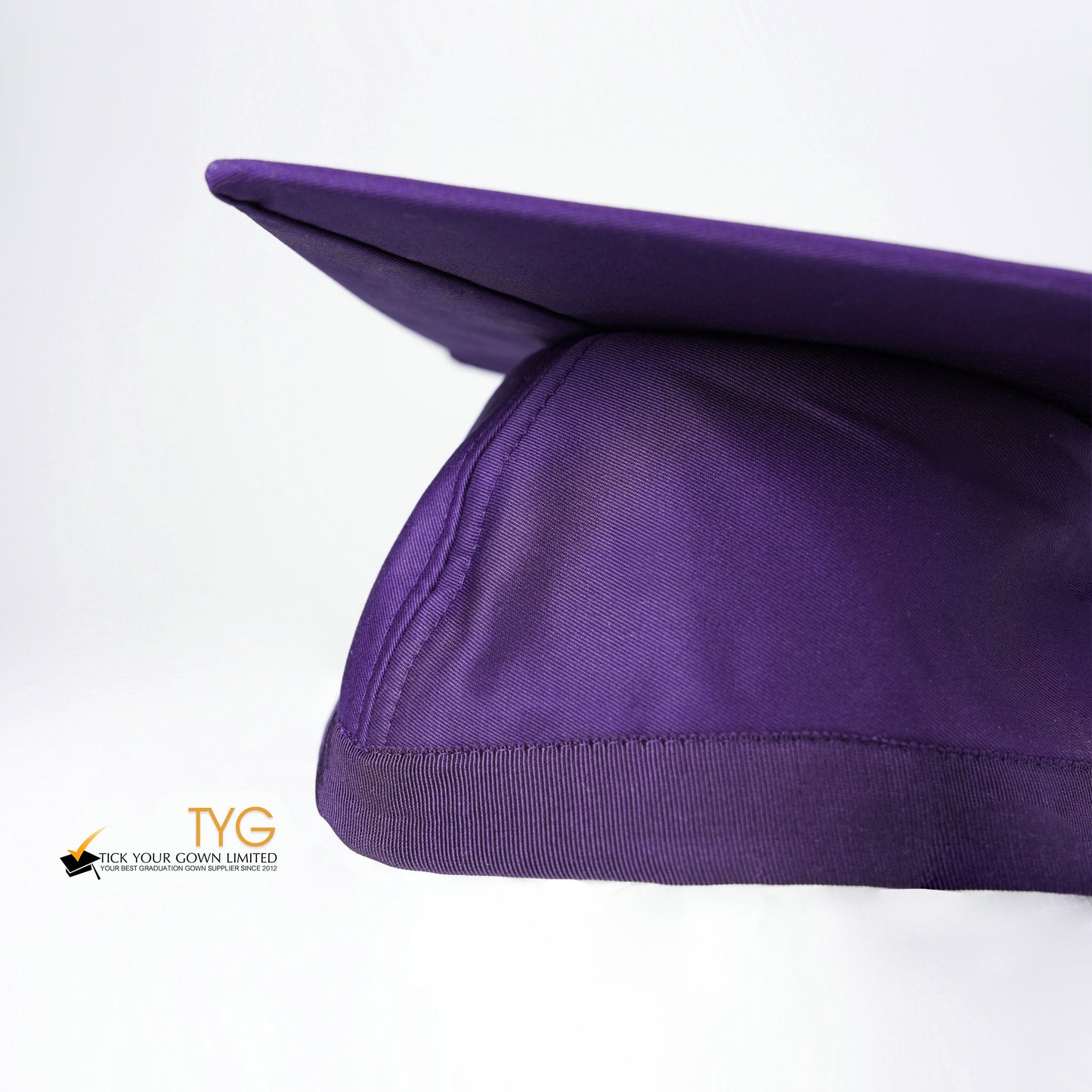 A detailed view of a purple graduation cap with a purple tassel on a white background.