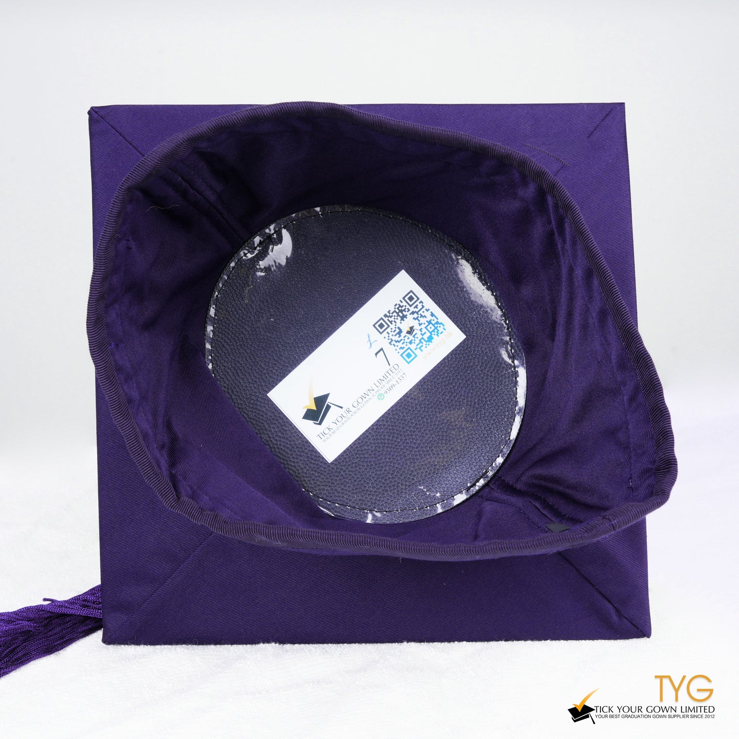 A detailed view of a purple tassel on a white background.
