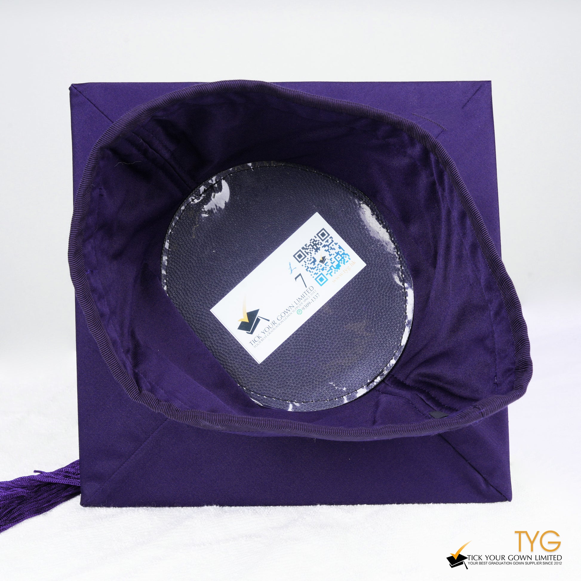A detailed view of a purple tassel on a white background.