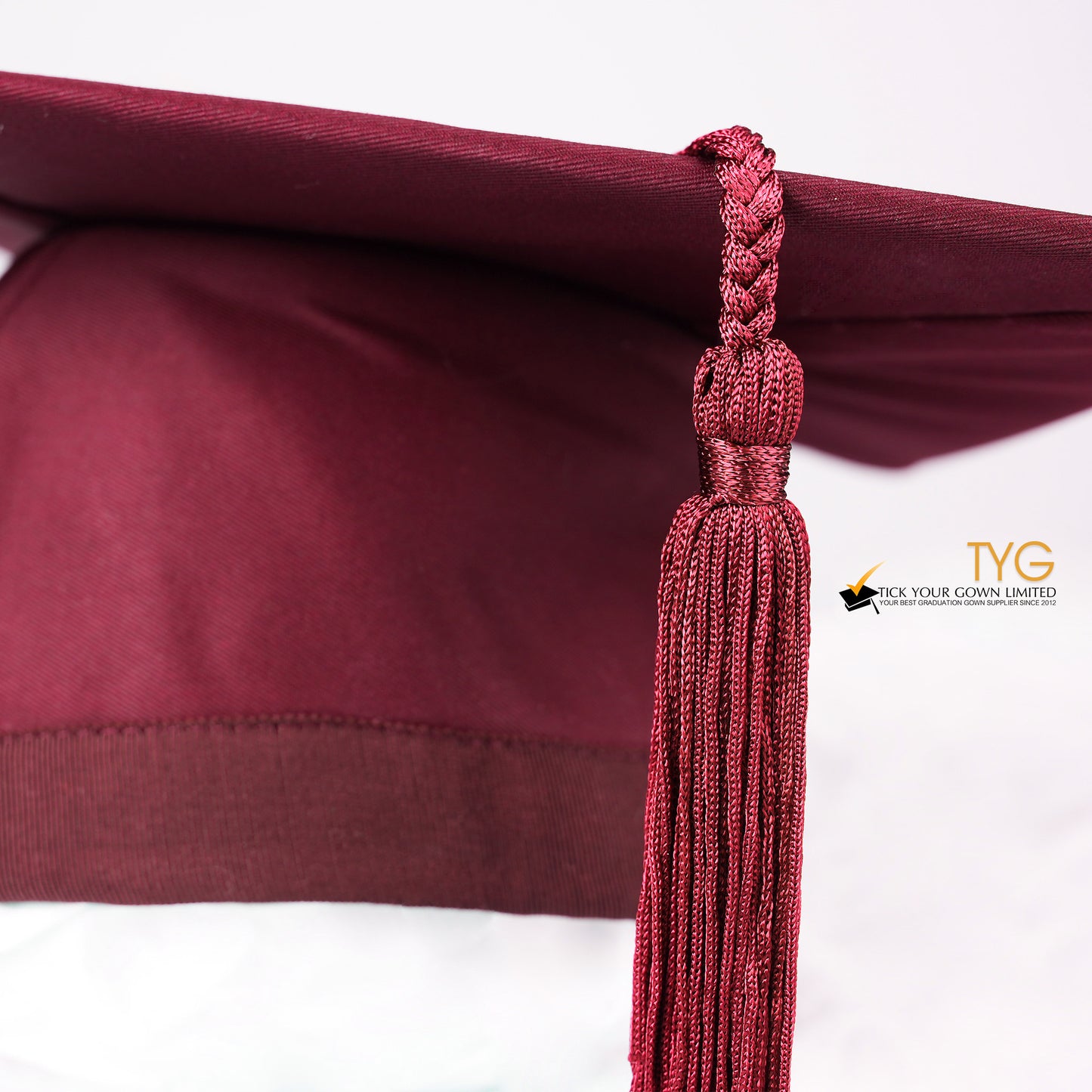 A detailed view of a red tassel on a white background.