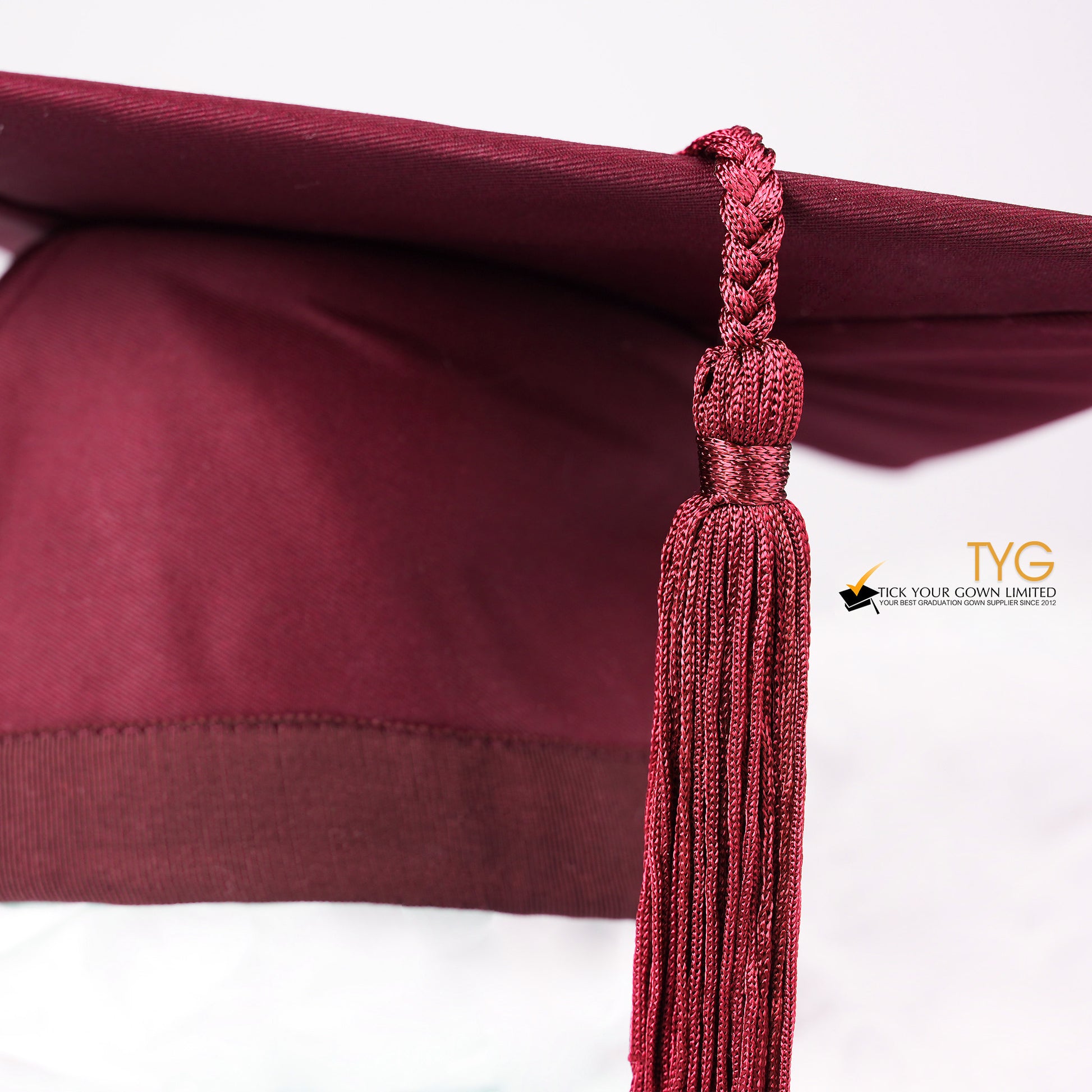 A detailed view of a red tassel on a white background.