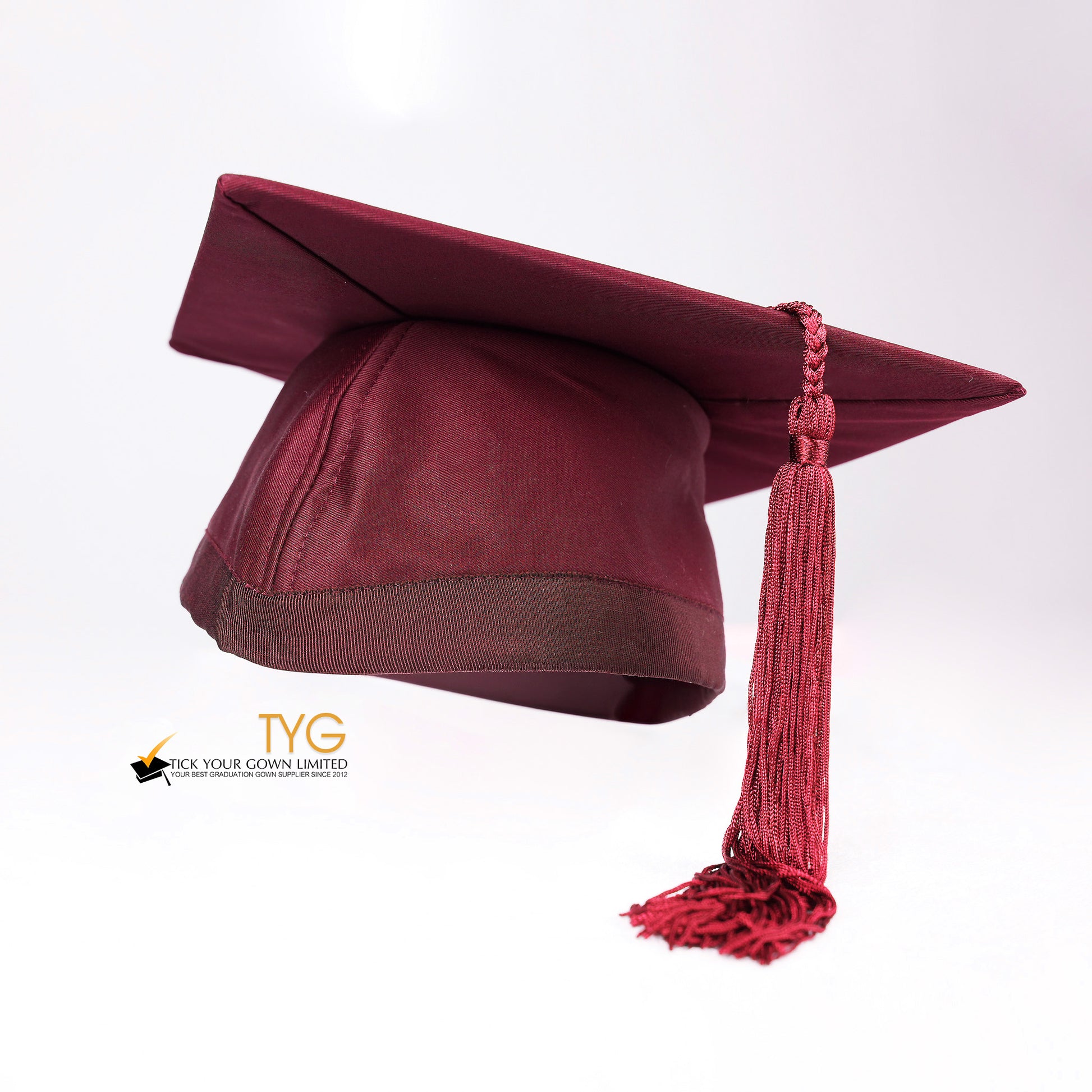 Red graduation cap with a red tassel on a white background.