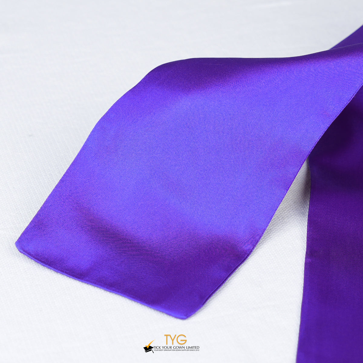 Detailed view of a purple graduation sash fabric on a white background.