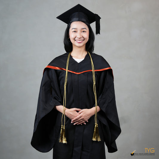 Graduate in black cap and gown with gold honour cords against a gray background