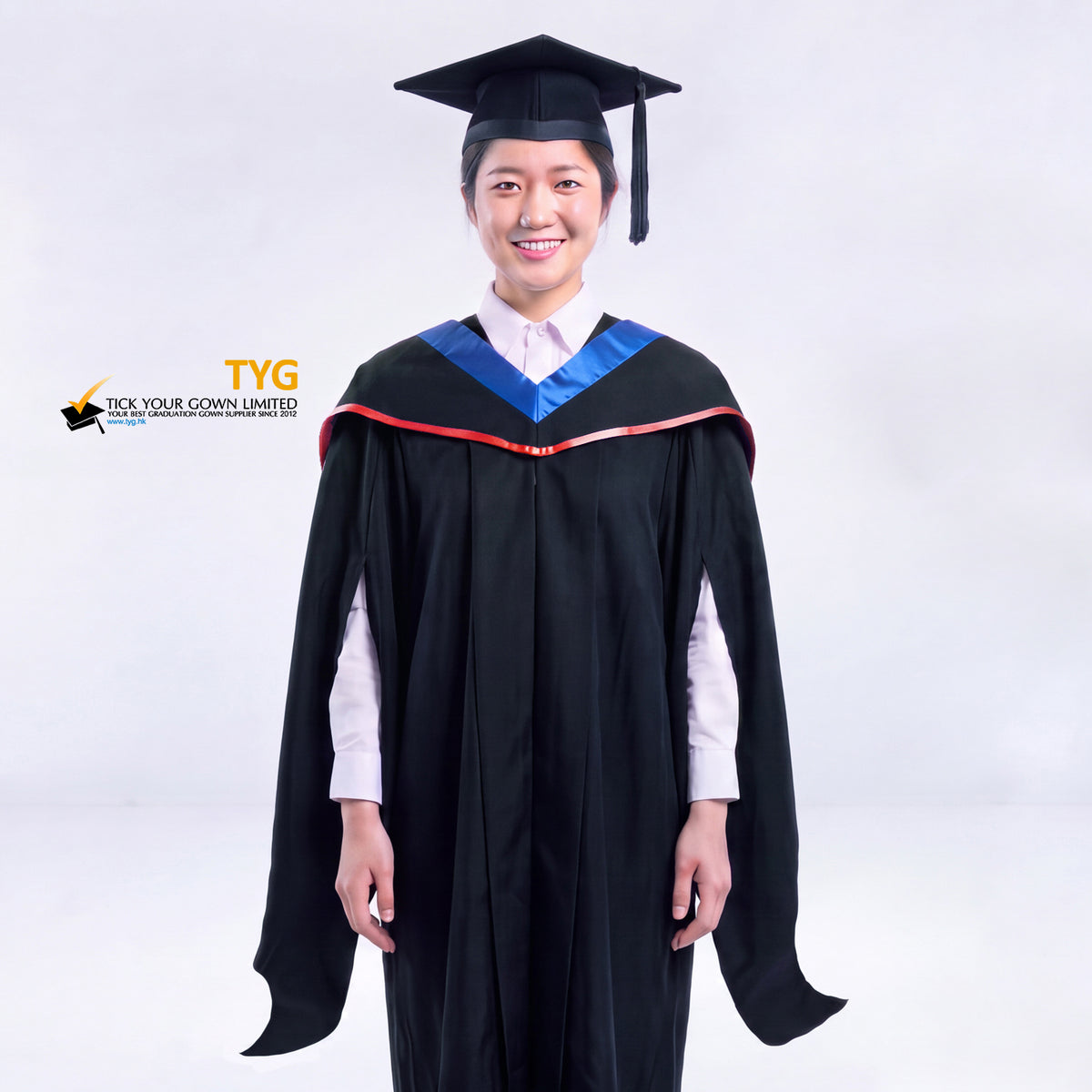 A woman in a black master's graduation gown classic UK with a blue hood with red accent and with a black mortarboard cap with an black tassel against a gray background.