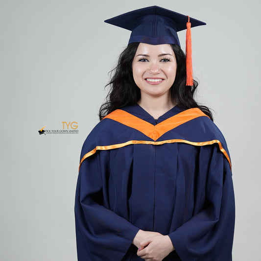 A person in a navy blue graduation gown and an orange hood and with a mortarboard cap with an orange tassel against a gray background.