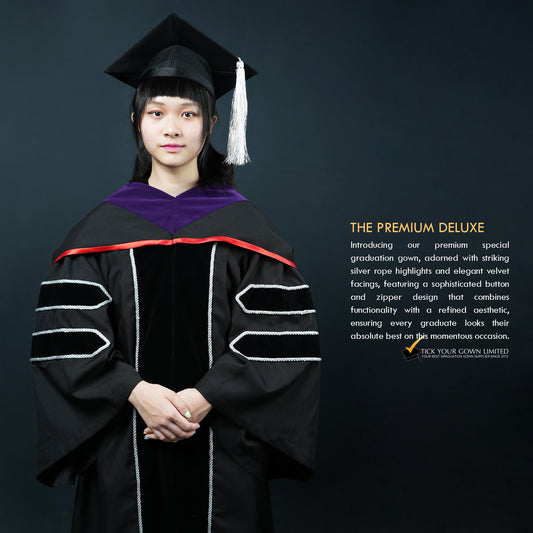 A person wearing a black velvet graduation gown with silver lining and a purple-and-red hood, a mortarboard witha silver tassel, standing in front of a dark background, with text describing the product as 'THE PREMIUM DELUXE'.