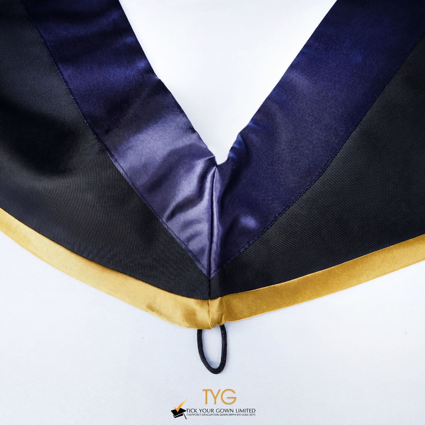 Close-up of a master's graduation hood with black body, dark navy blue satin hood and gold lining.