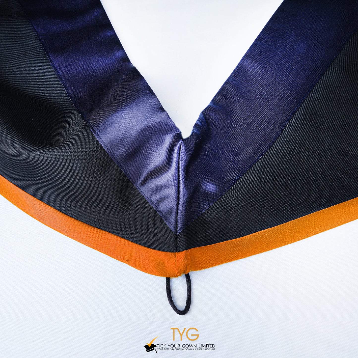 Close-up of a master's graduation hood with black body, dark navy blue satin hood and orange lining.