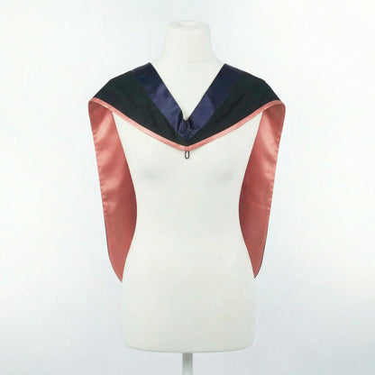 Master's graduation hood displayed on a mannequin showing full shape with black body, dark navy blue hood, and salmon pink satin lining.