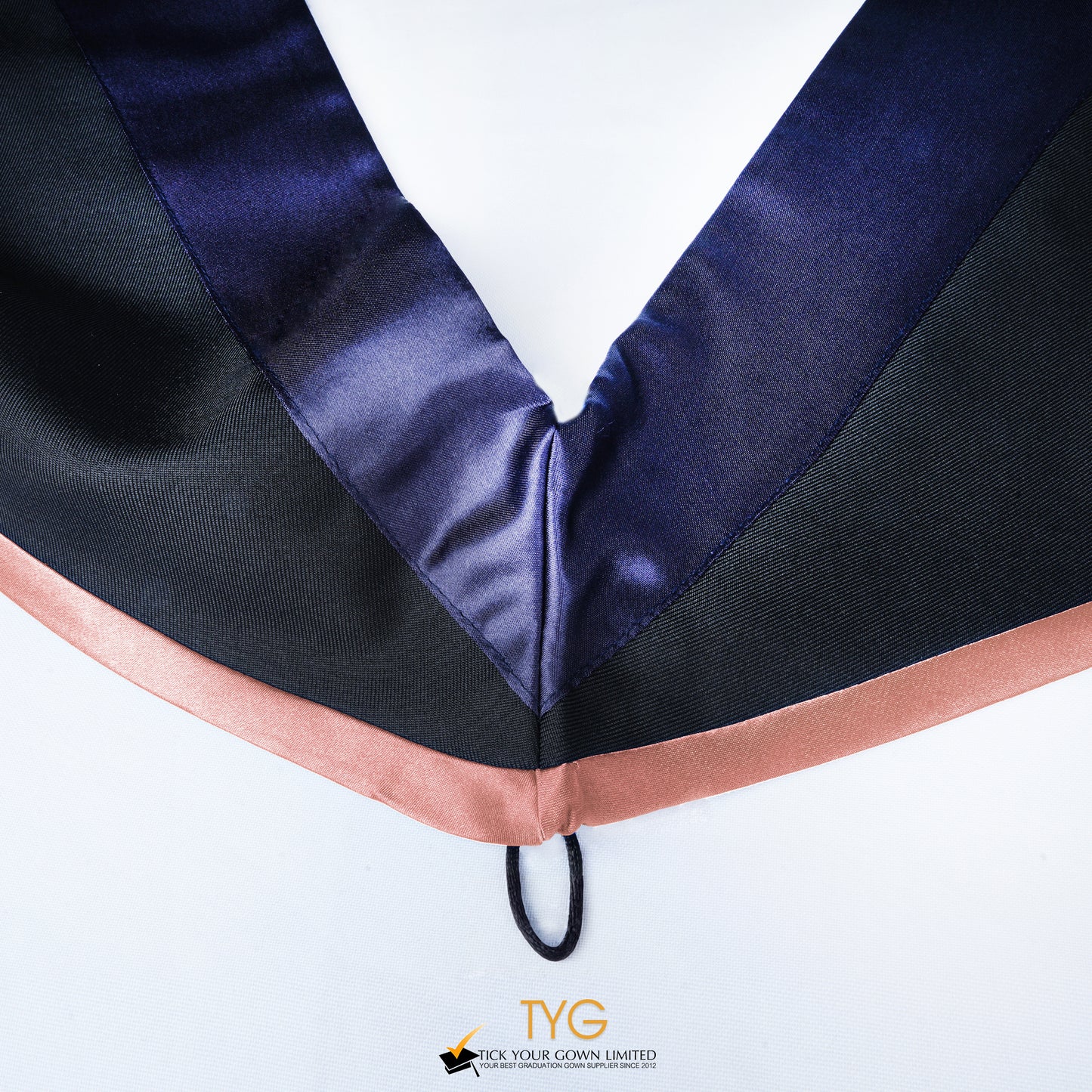 Close-up of a master's graduation hood with black body, dark navy blue satin hood and salmon pink lining.