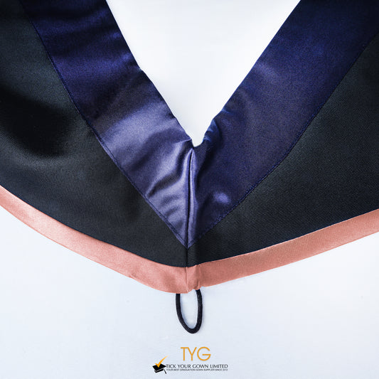 Close-up of a master's graduation hood with black body, dark navy blue satin hood and salmon pink lining.