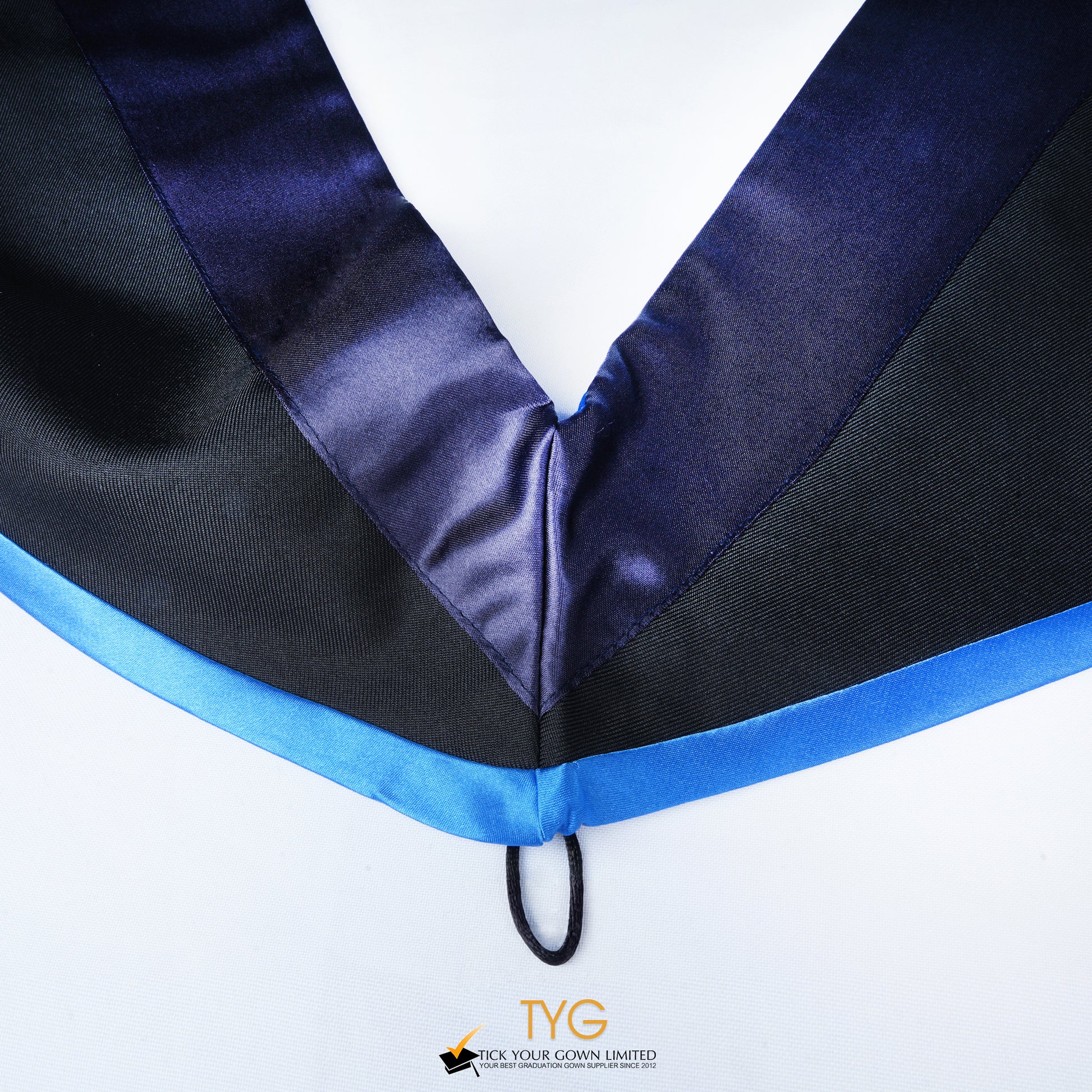 Close-up of a master's graduation hood with black body, dark navy blue satin hood and skyblue lining.