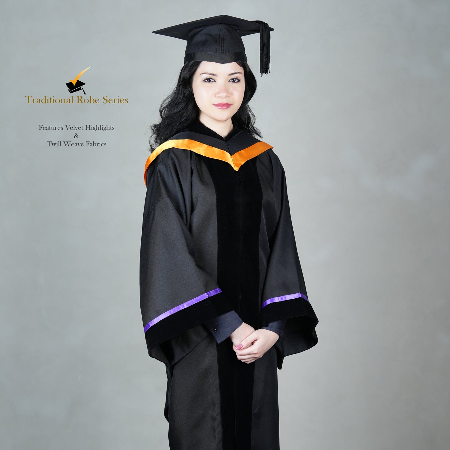 A person wearing a black Traditional Master's gown with a black velvet front panel, orange hood satin polyester trim, wide bell sleeves trimmed with purple satin with black velvet, and a matching black mortarboard cap, posed elegantly.