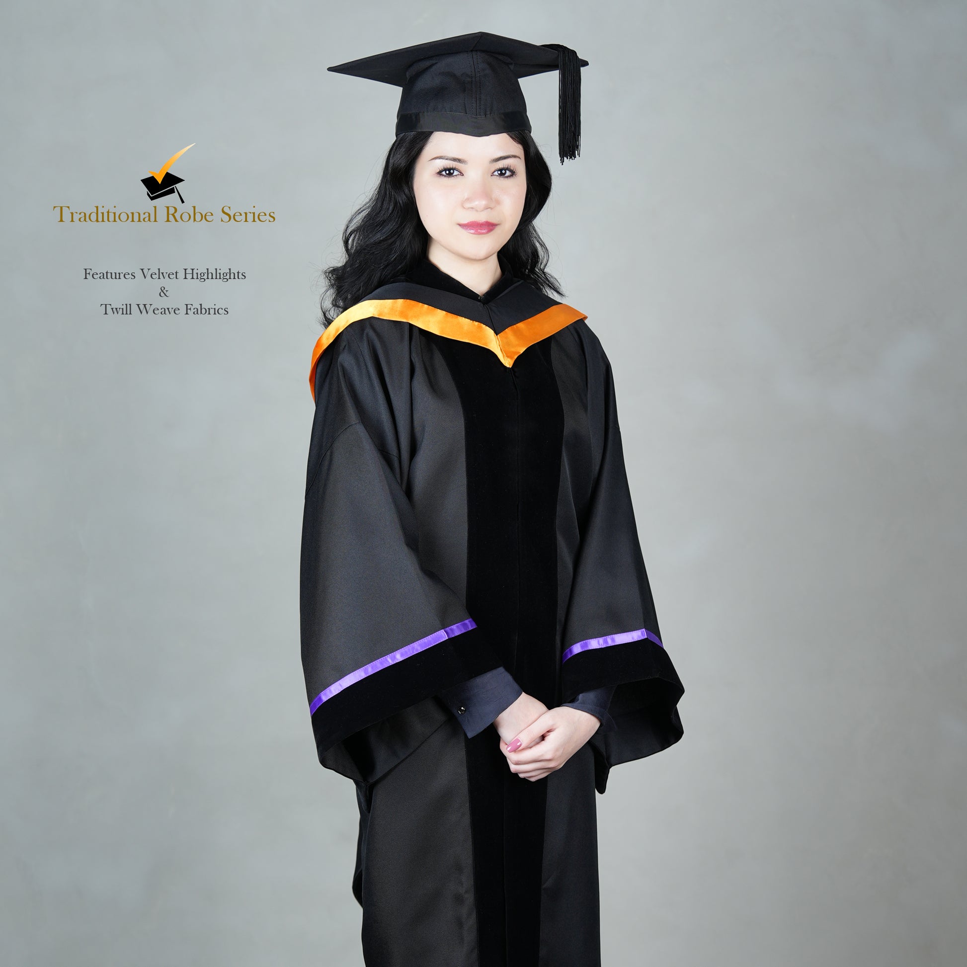 A person wearing a black Traditional Master's gown with a black velvet front panel, orange hood satin polyester trim, wide bell sleeves trimmed with purple satin with black velvet, and a matching black mortarboard cap, posed elegantly.