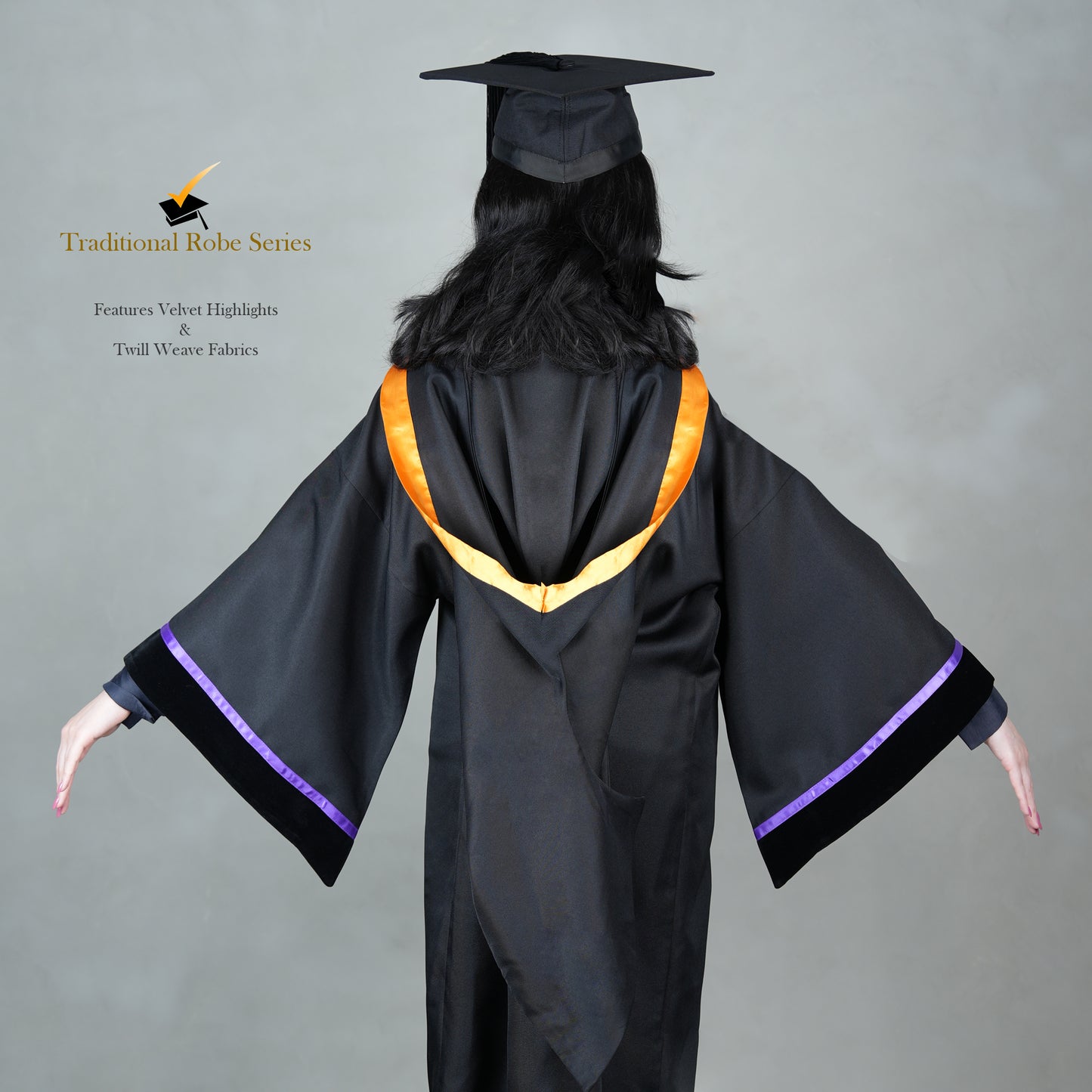 A back view of a woman posing in a black Traditional Master's graduation regalia featuring a black gown, orange hood satin polyester trim, wide bell sleeves trimmed with purple satin with black velvet cuffs, and a matching black mortarboard cap.