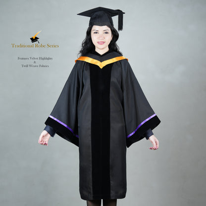 A woman posing in a black Traditional Master's graduation regalia featuring a black velvet front panel, orange hood satin polyester trim, wide bell sleeves trimmed with purple satin with black velvet cuffs, and a matching black mortarboard cap.