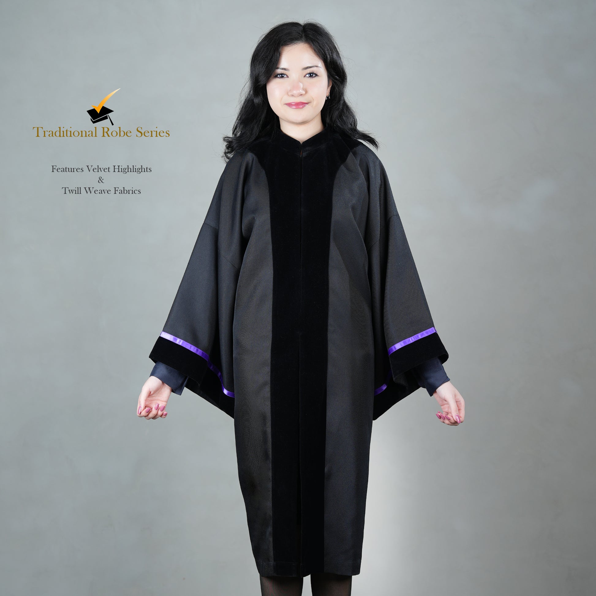 A person wearing a black Traditional Master's graduation gown with a front velvet panel, including satin velvet cuffs paired with black velvet, posed elegantly, without a hood or mortarboard.