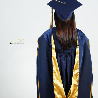 A detailed back view of a person wearing a PhD classic navy blue velvet graduation gown with yellow lining hood, and a navy blue doctoral bonnet with gold tassel.