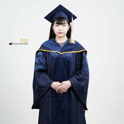 A detailed front view of a person wearing a PhD classic navy blue velvet graduation gown with yellow lining hood, and a navy blue doctoral bonnet with gold tassel.