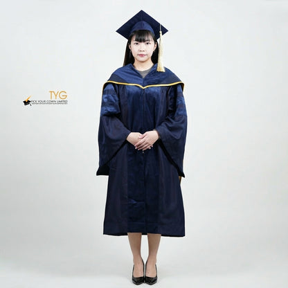 Front view of a person wearing a PhD classic navy blue velvet graduation gown with yellow lining hood, and a navy blue doctoral bonnet with gold tassel.