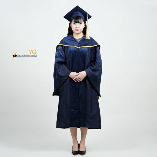 Front view of a person wearing a PhD classic navy blue velvet graduation gown with yellow lining hood, and a navy blue doctoral bonnet with gold tassel.