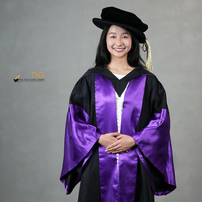 A detailed front view of a person wearing a graduation gown in black with purple satin panels, matching purple satin sleeve cuffs, and a black doctoral bonnet with gold tassel.
