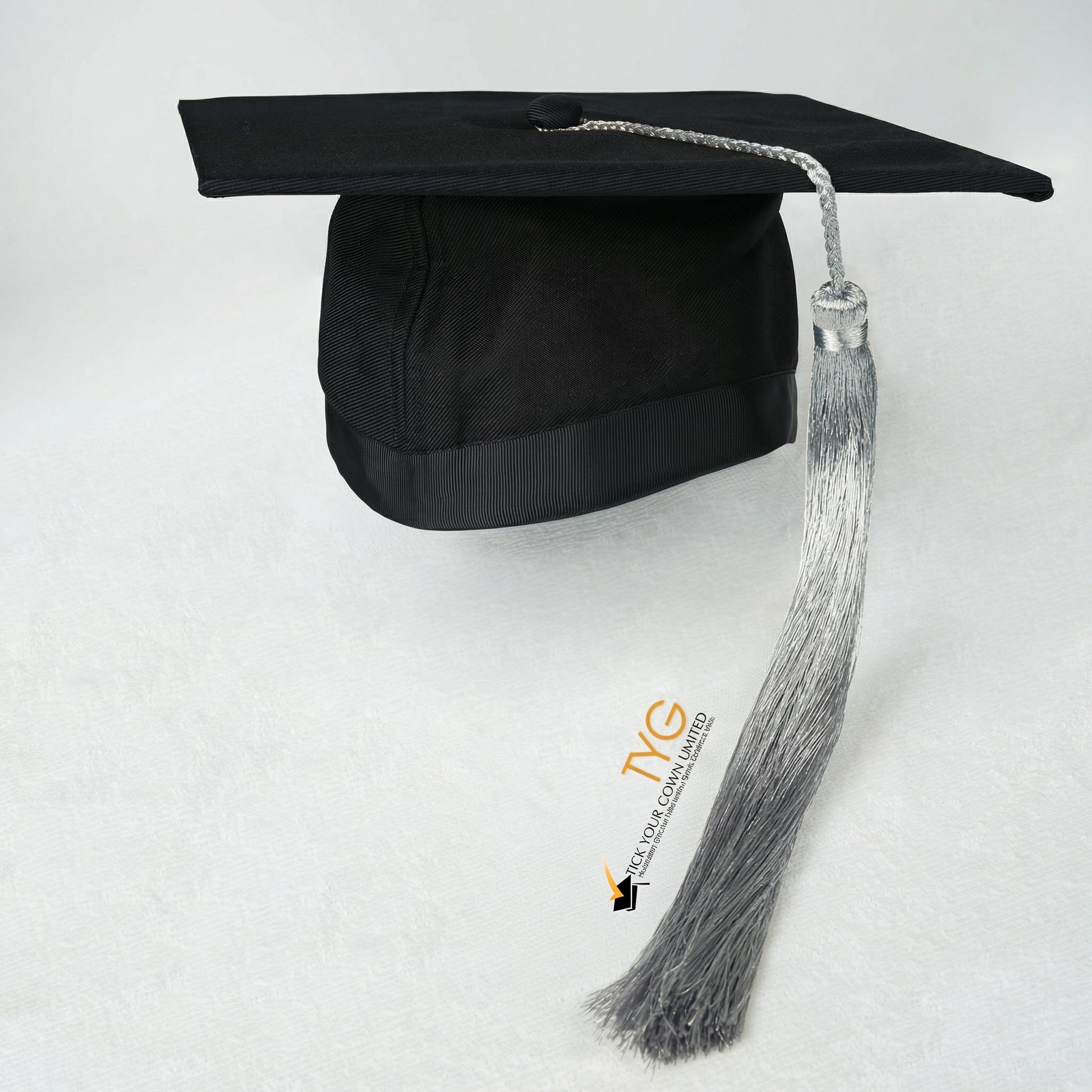 Black graduation cap with silver tassel on a white background