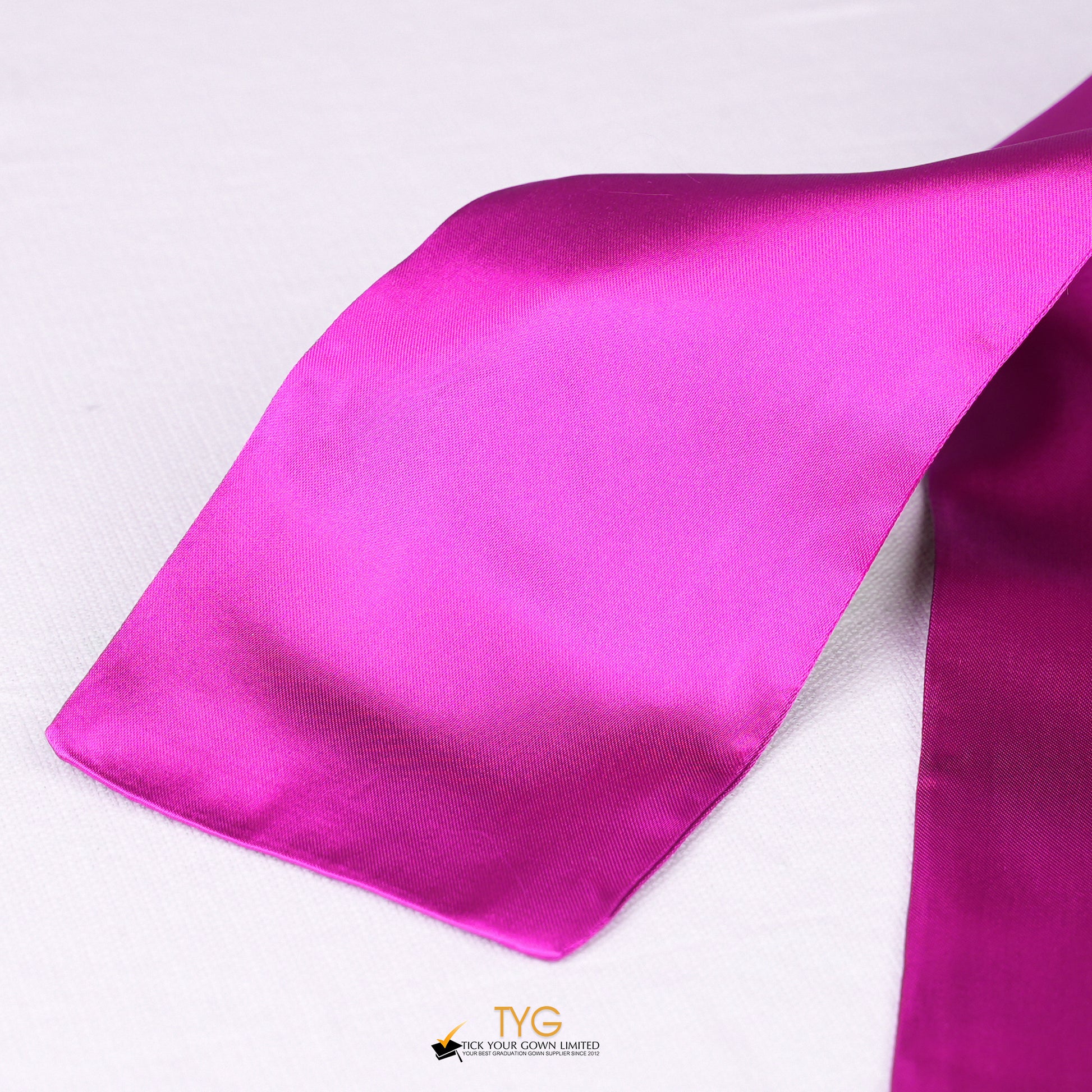 Detailed view of a pink graduation sash stole fabric on a white background.